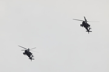 Two military choppers helicopters flying in formation. 