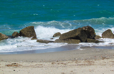 Group of rocks hit by the waves of the Mediterranean Sea. The photo was taken in Messina, along the Sicilian coast, in Italy
