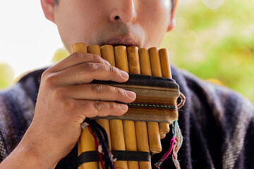 bolivian, peruvian, ecuadorian man playing zampoña
