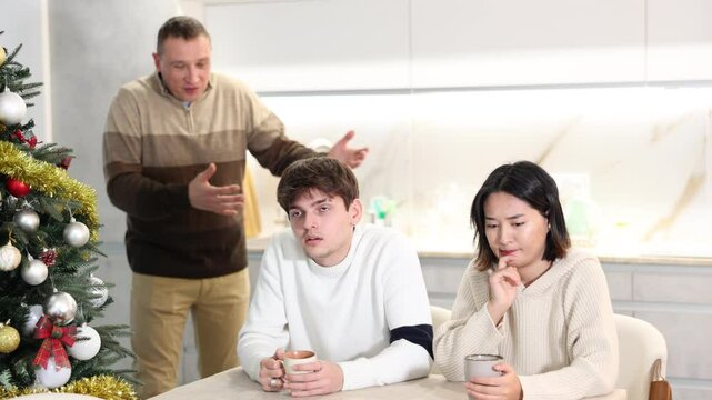 Domestic quarrel during Christmas celebration - father scolds and shouts at young people. High quality 4k footage