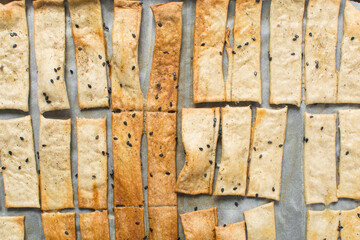 Overhead view of homemade crackers, top view of freshly baked black sesame cracker biscuits,...