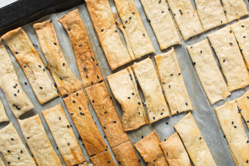 Overhead view of homemade crackers, top view of freshly baked black sesame cracker biscuits,...