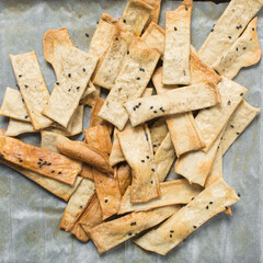 Overhead view of homemade crackers, top view of freshly baked black sesame cracker biscuits,...