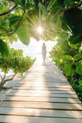 Fototapeta premium A person walks on a wooden boardwalk surrounded by lush greenery as the sun peeks through the leaves. Tranquil nature escape