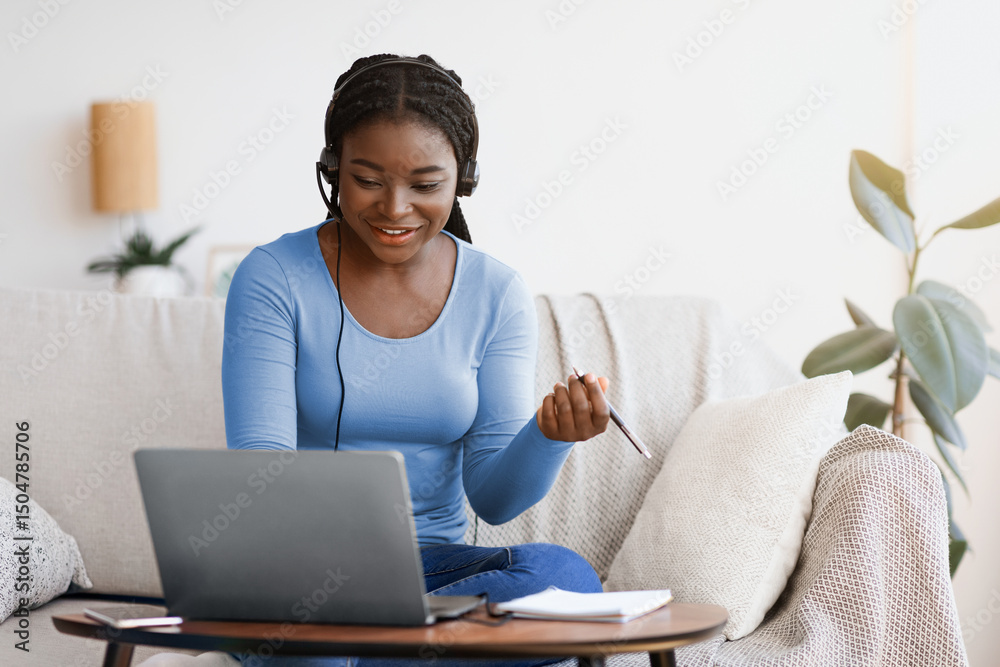 Aufkleber Millennial African Lady In Headset Watching Webinar On Laptop At Home, Having Online Training, Studying With Computer And Taking Notes To Notepad, Enjoying Distance Learning, Copy Space