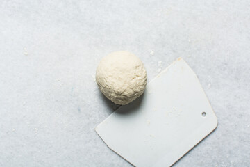 Overhead view of dumpling wrappers dough being mixed on a granite countertop, process of making wonton skins dough, process of making homemade dumplings