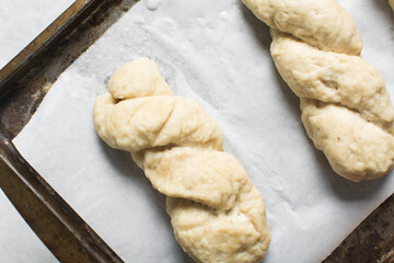 Overhead view of homemade pretzels dough on a baking tray, top view of freshly boiled soft pretzel dough on a white background