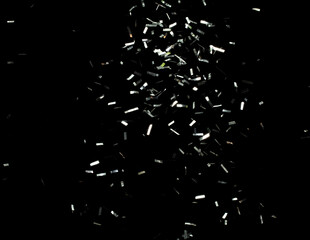 Many Party glitter scatter in many group. Silver Confetti Foil fall splashing in air. Silver Confetti Foil explosion flying, abstract cloud fly. Black background isolated element freeze