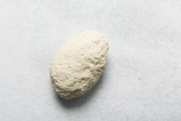Overhead view of steamed bun dough on a white granite countertop, top view of mantou dough being mixed, process of making steamed buns