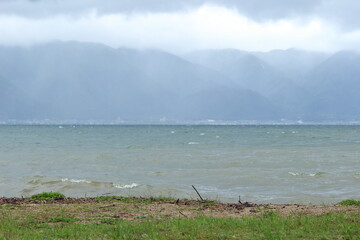 琵琶湖岸に寄せる波と霧に霞む対岸の風景