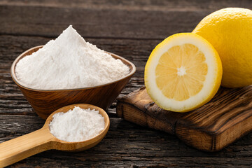 Citrus Limon - Yellow lemon fruit with baking soda in a bowl and spoon