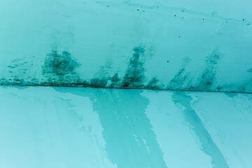 Close-up of a textured surface with an abstract pattern featuring shades of teal and blue, offering a unique visual texture with an aged or weathered effect. Ideal for creative backgrounds.