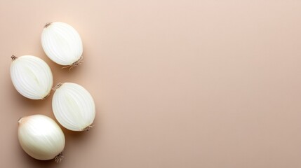 Halved white onions on beige background, copy space, food photography
