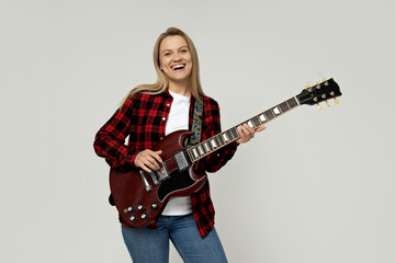 Attractive young girl playing the guitar on a white background