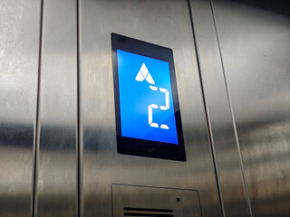 Close-up shot displaying an elevator panel highlighting floor number and direction, creating a sense of modern accessibility and urban convenience in indoor transportation settings.