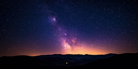 A breathtaking view of the Milky Way stretching across a dark, clear night sky above a mountain range