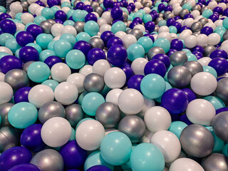 A vibrant array of colorful plastic balls creates a captivating visual texture, evoking feelings of joy and playfulness. The composition presents a lively and inviting scene for children.
