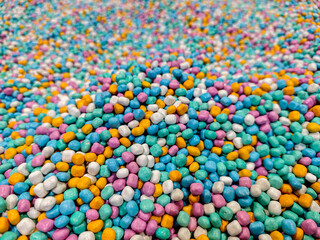 A vibrant assortment of candy-coated treats creates an enticing backdrop, perfect for a variety of creative projects and designs. This colorful confectionery is visually appealing and fun.