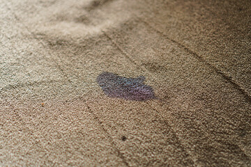 Close-up shot showcasing a stain on a neutral-toned carpet, highlighting household mishaps and the challenges of maintaining clean interiors, ideal for home care and cleaning product themes.