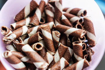A close-up shot captures the delightful texture and inviting appearance of rolled wafer cookies,...