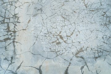 Intricate patterns of cracks spread across a textured surface create an abstract and visually captivating design, suitable for a variety of artistic and decorative contexts and backgrounds.
