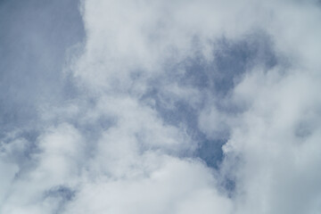 Sky filled with fluffy clouds creates a soft and airy atmosphere, perfect for evoking feelings of tranquility and peace, conveying open space and weather themes or background designs.