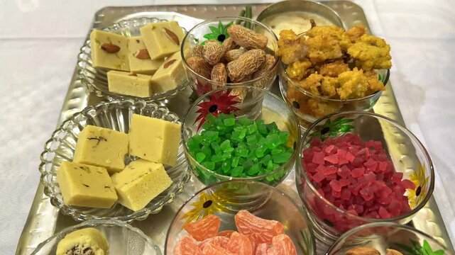 Tracking shot of a varity of indian sweets on the plater,