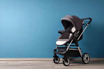 A grey stroller with a hooded canopy sits against a light blue wall on a wood floor