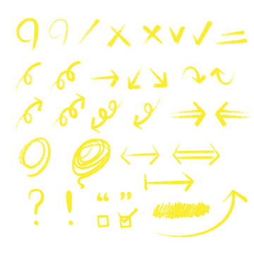 A collection of arrows, circles, and symbols drawn with yellow colored pencils and crayons on rough surfaces