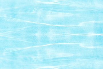Fototapeta premium Blue water with ripples on the surface. Defocus blurred transparent blue colored clear calm water surface texture with splashes and bubbles. Water waves with shining pattern texture background.