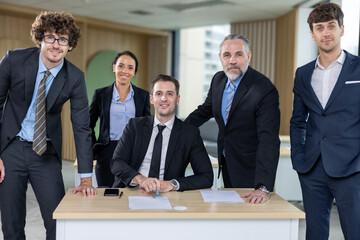 Diverse Team Working Together in Modern Co-Working Space. Casual meeting of smiling diverse business team analyzing financial data. Multiethnic business people working together in the office.