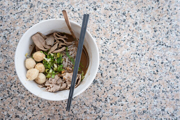 Thai pork noodles on a marble table..