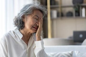 Elderly asian woman touching face while suffering from eye strain with discomfort, dry eyes or...