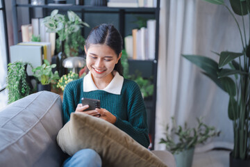 Asian woman using voice assistant on smartphone at home conversation with online assistant Voice...