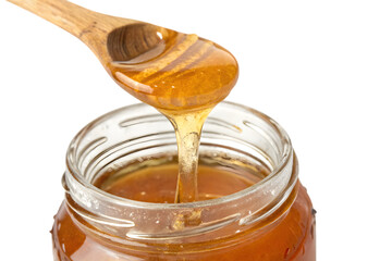 Glass Jar of Honey Drizzling Over Wooden Spoon on White Transparent Background - Isolated