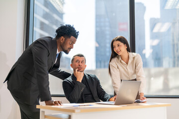 Diverse business team meeting and discussing marketing research and strategy using laptop, collaboration and communication planning, analysis, brainstorming for innovation, productivity, leadership
