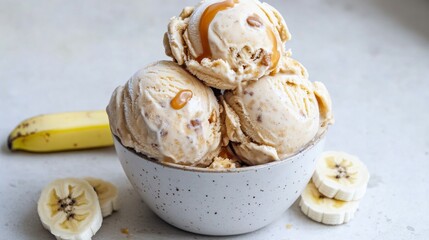 Fototapeta premium Creamy Banana Ice Cream with Caramel Drizzle in White Bowl