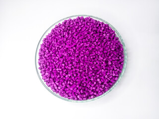 Pink masterbatch granules, polymer carrying pink pigment poured into isolated glass cup container with white background, suitable for making product catalog design visualization for plastic manufactur