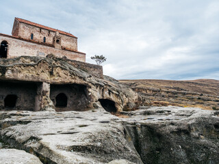Fototapeta premium Uplistsikhe (the Lord's Fortress), the amazing UNESCO World Heritage site of cave city, ancient rock town with nature stone, and old building, blue sky background, famous travel attraction at Georgia.