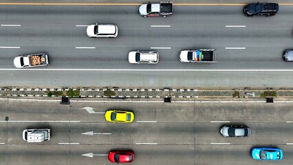 A bustling highway sprawls beneath, an intricate web of lanes interwoven with cars, trucks, and motorcycles, each a vibrant thread in the tapestry of motion.
