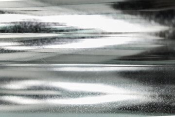A macro shot layers of silver metallic material, with a blurred effect creating a dynamic depth....