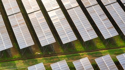 From above, the solar panel field represents a sustainable solution to energy demands, emphasizing the importance of clean, green energy sources in tackling climate change.
