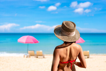 Young woman traveler relaxing and enjoying the beautiful tropical white sand beach at diamond beach in Nusa Penida island, Bali