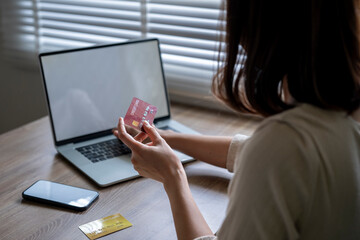A woman is using a laptop to check her credit card balance