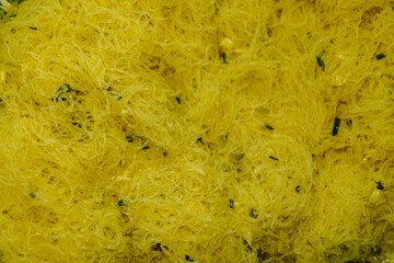 An intricate web of translucent yellow vermicelli noodles create a visually appealing culinary texture, ideal for illustrating diverse and appetizing ingredient options and recipes.