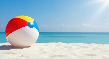 Obraz premium Colorful inflatable beach ball rests on white sand with turquoise ocean and clear blue sky. Summer fun, vacation playtime. For family holidays, kids activities, travel brochures