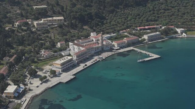 Wide Cinematic drone shots revealing the sacred grounds of Archangel Michael Monastery at Panormitis bay. The aerial view captures the monastery's peaceful setting surrounded by pristine waters.