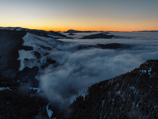 Winter hiking to Sina in Low Tatras National park near jasna is full of beautiful views. Sunset in Slovakia mountains with Chopok peak.