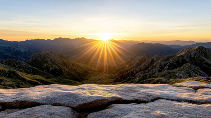 Golden sunrise illuminating mountain range with rocky foreground and vibrant sky