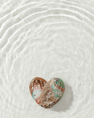 Two natural seashells forming heart, sea water gentle ripples cast soft, wavy shadows on clean, light-color background, summer, serene, minimalist aesthetic concept. Feelings of love, tranquil